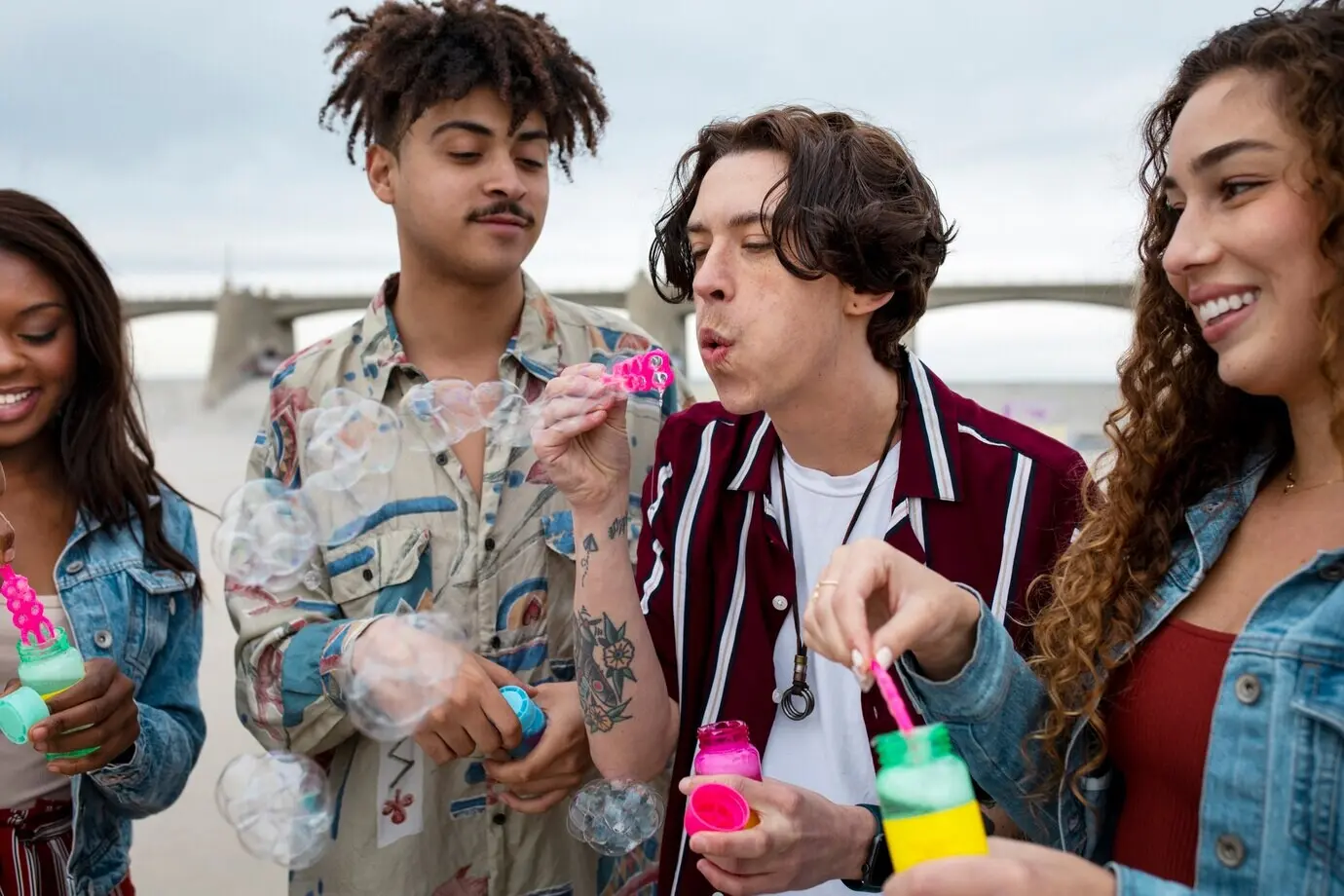 Друзья выдувают пузыри, гуляя по городу.